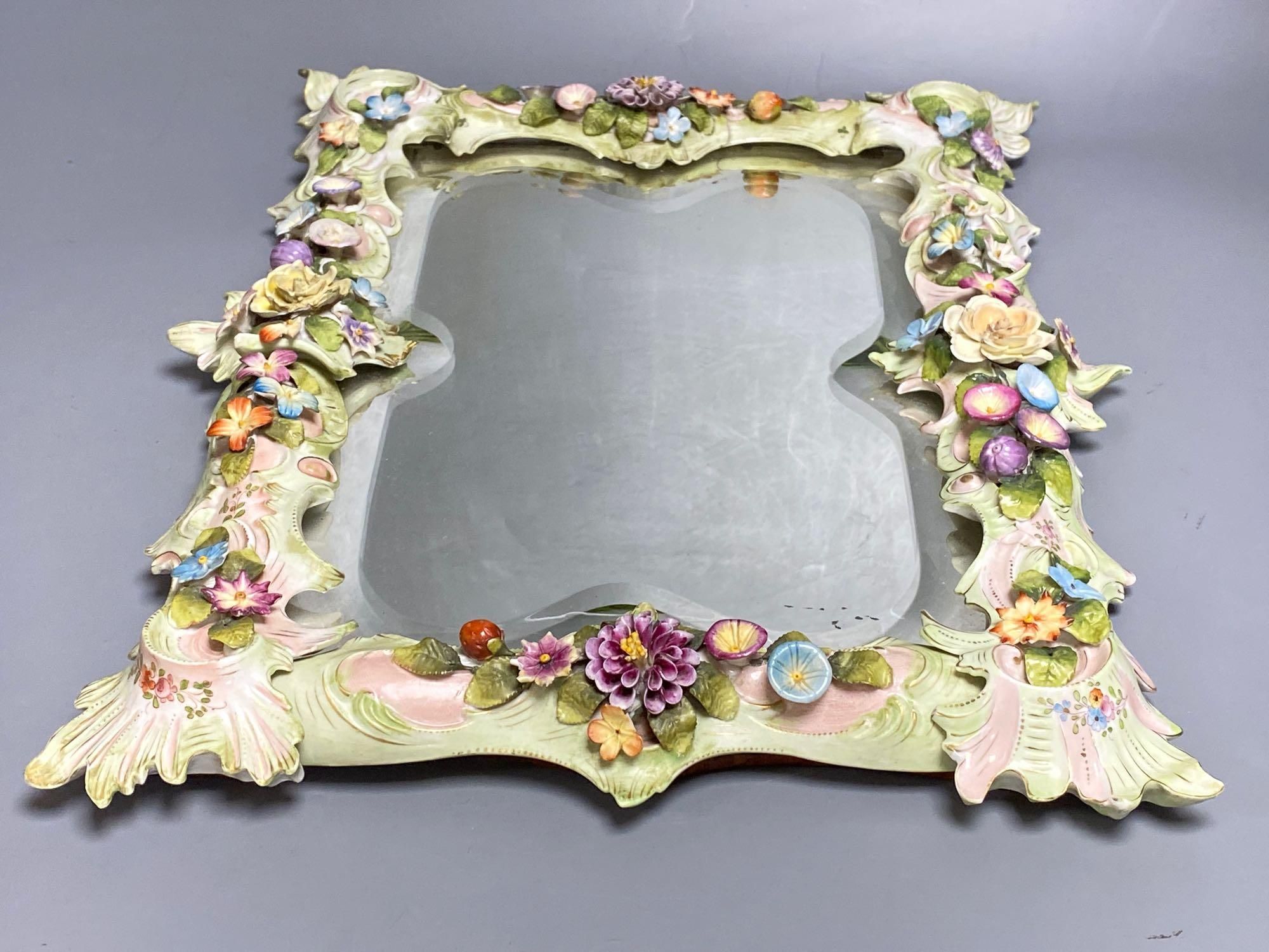 A porcelain floral encrusted wall mirror, German, Von Schierholz, 30 x 40cm